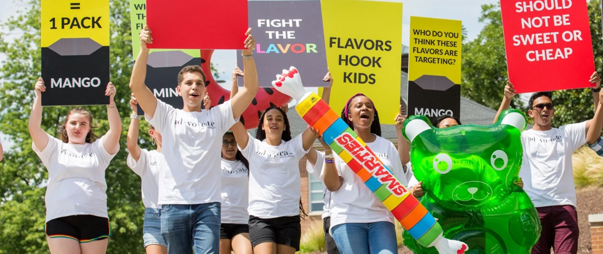 młodzież trzymająca w rękach banery z napisami dot. zaprzestania palenia papierosów 