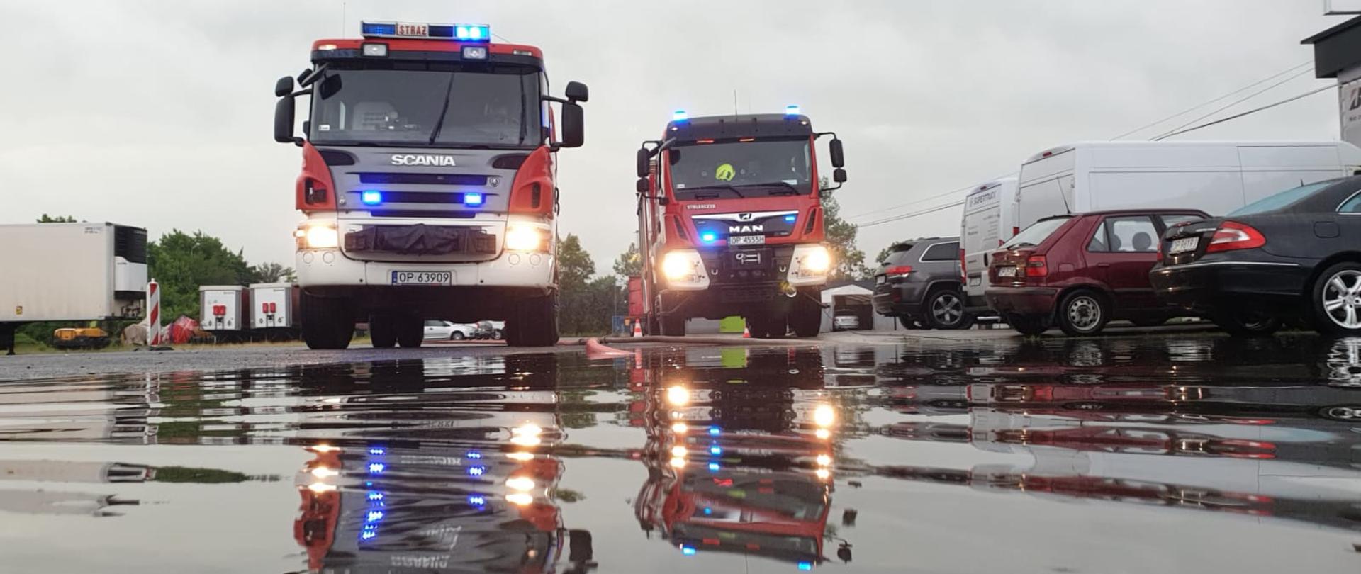 Strażacy usuwają skutki porannego frontu burzowego, który przeszedł w dniu 24 czerwca 2021 roku nad województwem opolskim. Na zdjęciu dwa pojazdy pożarnicze (PSP i OSP) podczas usuwania skutków nawalnego deszczu.
