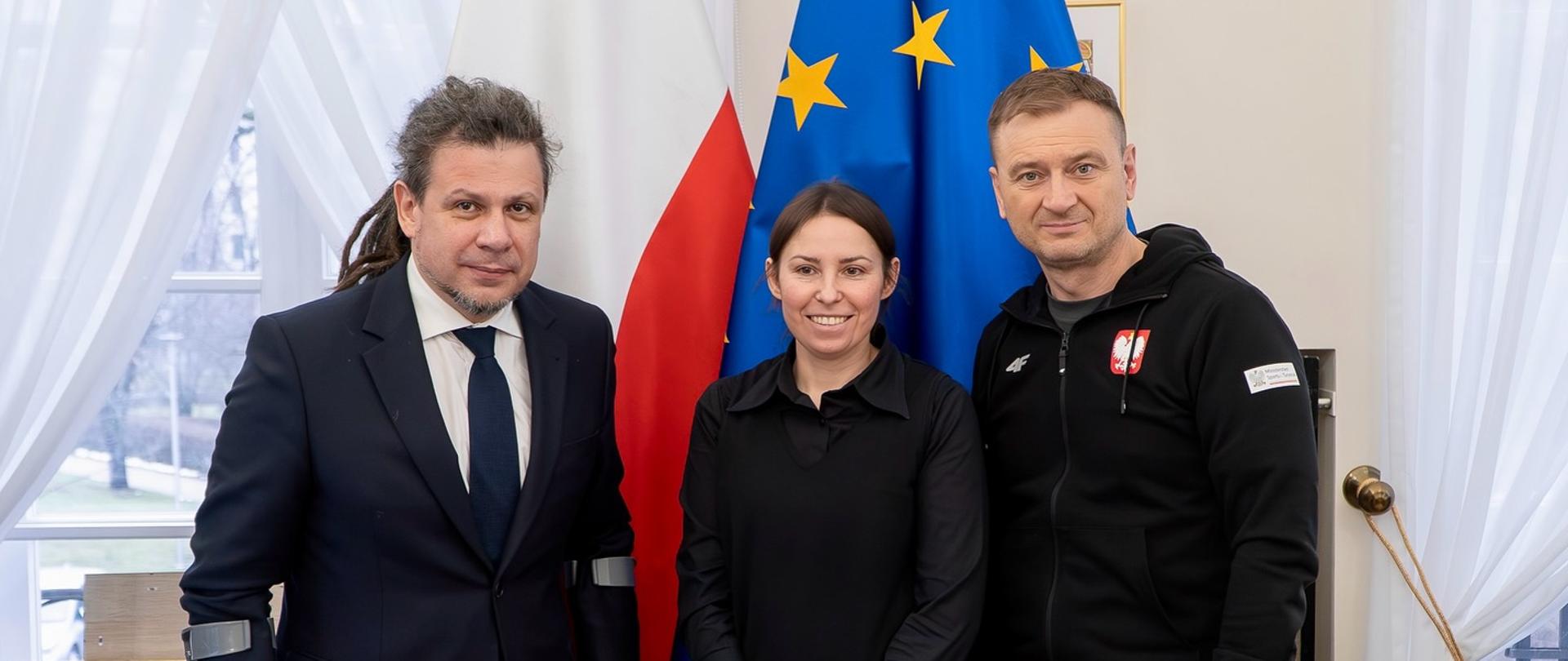 Na zdjęciu od lewej: Łukasz Szeliga – prezes Polskiego Komitetu Paralimpijskiego; Barbara Dąbrowska, wdowa po Michale Dąbrowskim i Minister Sportu i Turystyki Sławomir Nitras. W tle flagi Polski i Unii Europejskiej.