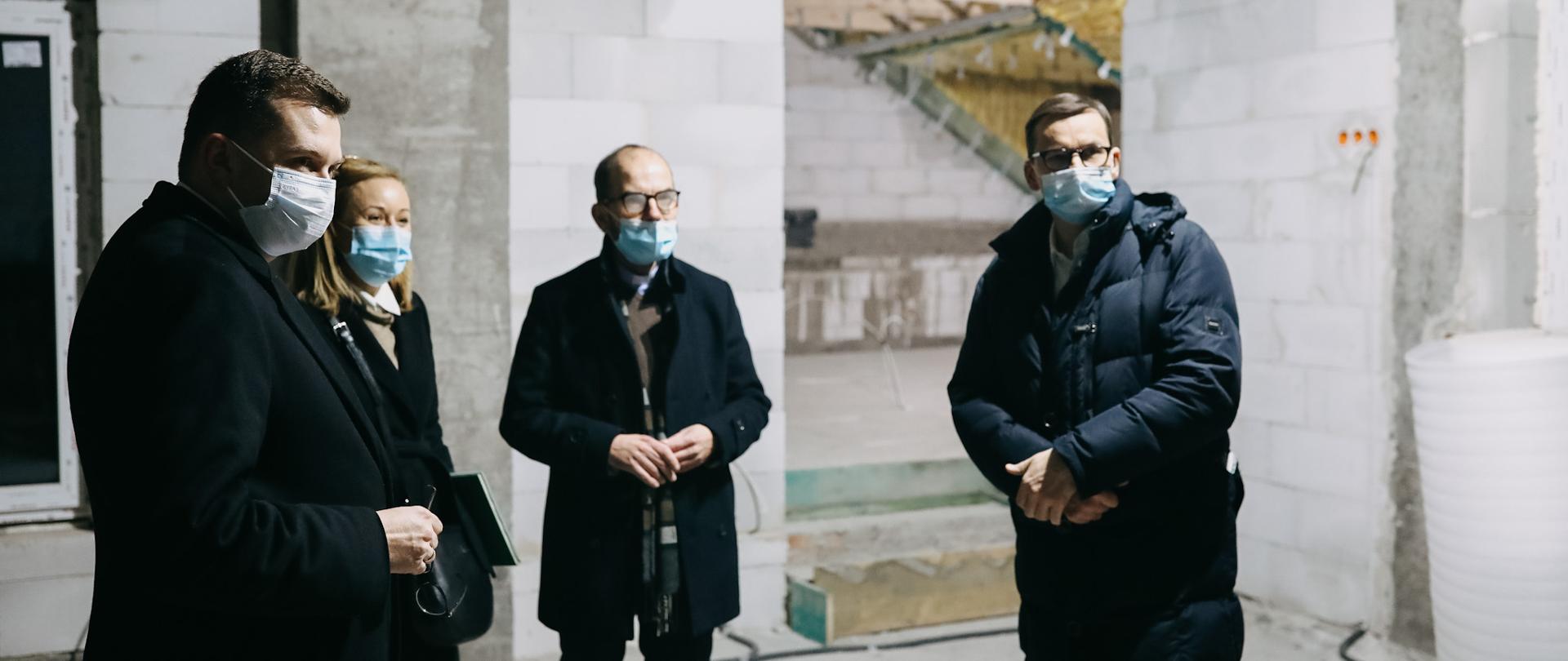 Premier wraz z pozostałymi stoją na terenie budowy.