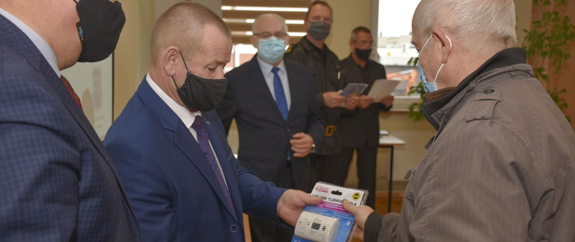 Zdjęcie przedstawia wręczenie czujek laureatom konkursu