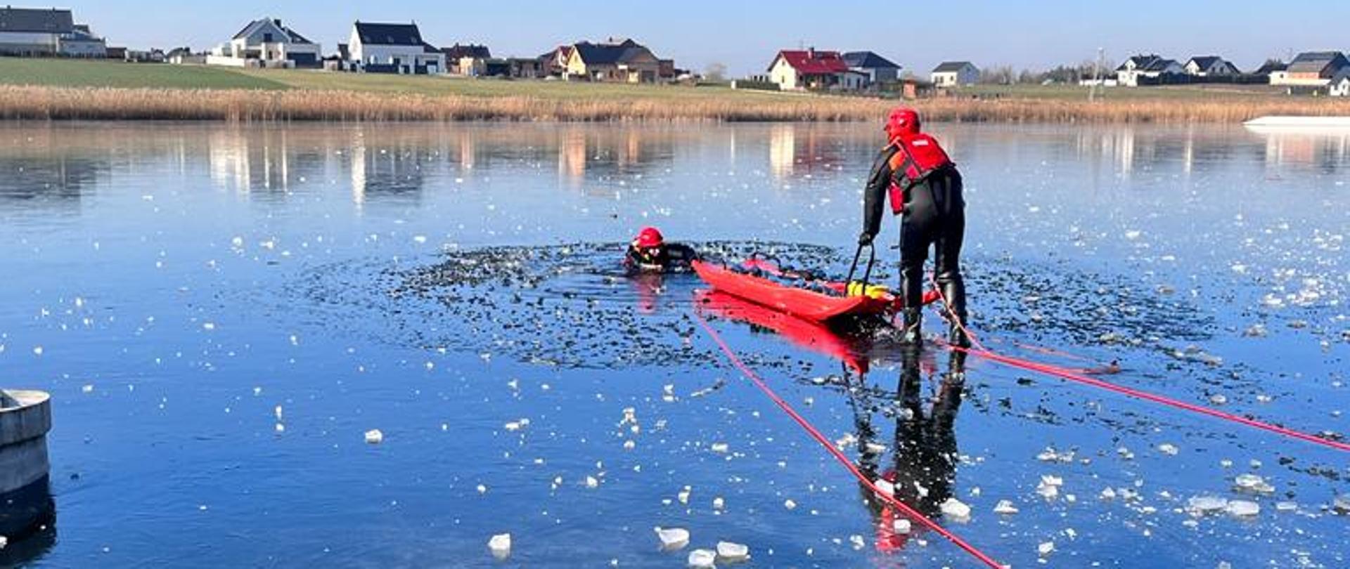 Na zdjęciu ratownicy ćwiczą na zamarzniętym akwenie podejmowanie osoby z przerębli