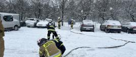Strażacy OSP sprawiający linię gaśniczą, opady śniegu