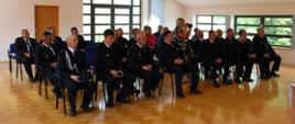Zdjęcie grupowe - przedstawia druhów OSP w mundurach. Zdjęcie wykonane wewnątrz budynku. 