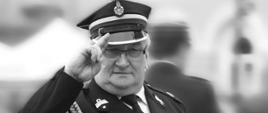 śp. dh. Józef Cholewka w mundurze wyjściowym strażaka ochotnika i rogatywce salutuje. Widoczny z przodu. Zdjęcie czarnobiałe - popiersie.