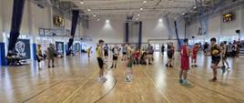 Młodzi koszykarze podczas rozgrzewki w hali sportowej