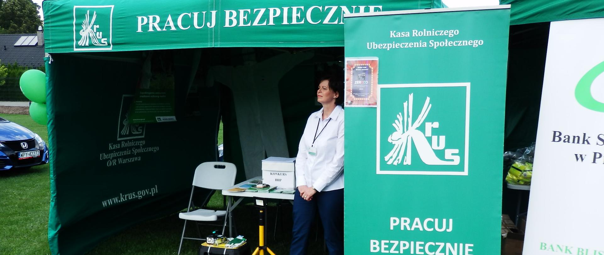 Kobieta stoi przy stoisku KRUS