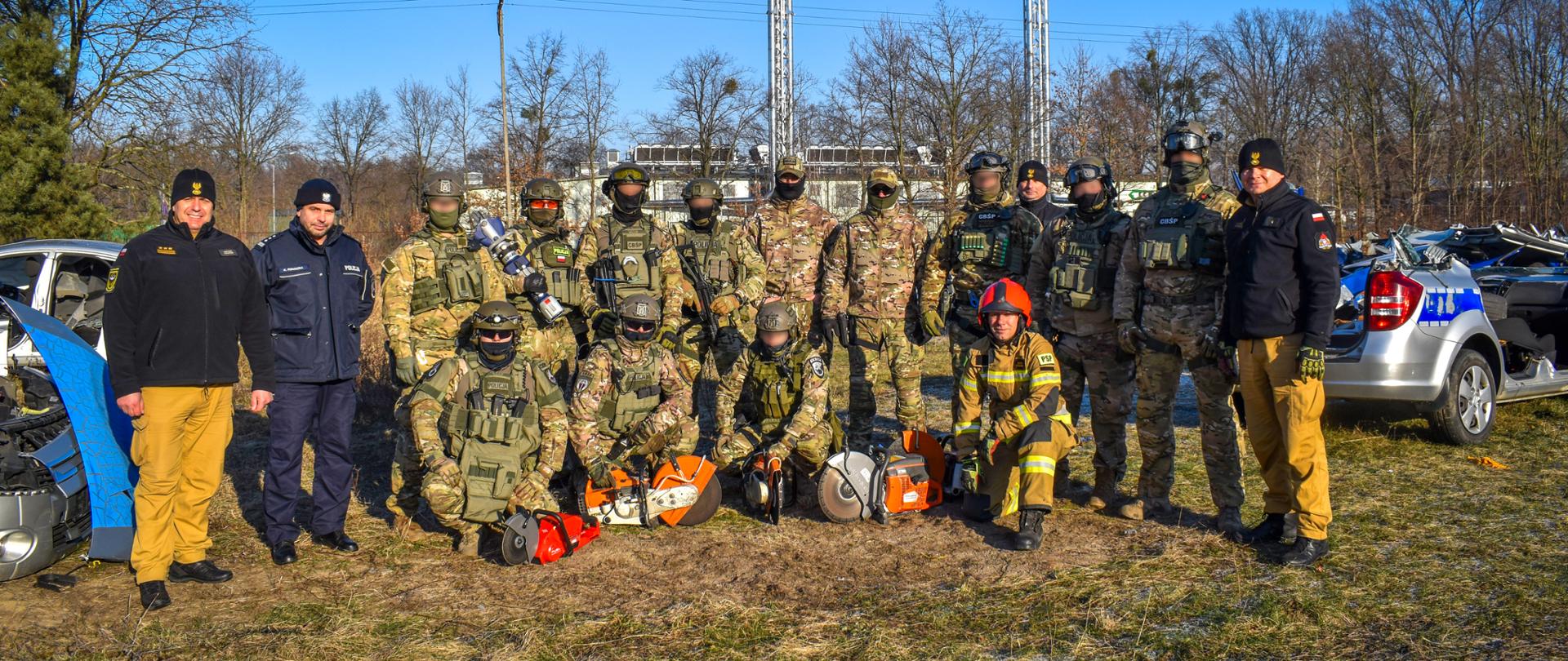 Funkcjonariusze pozujący do zdjęcia w umundurowaniu na trawie.