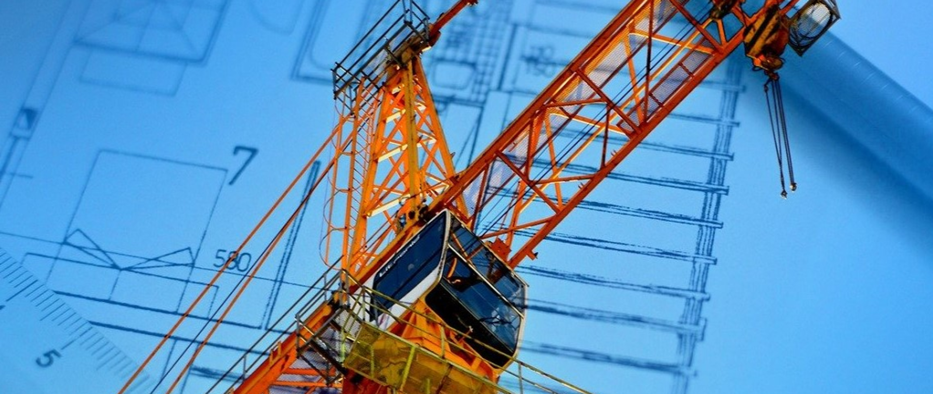 Pomarańczowy dźwig na tle rysunku projektu budowlanego 