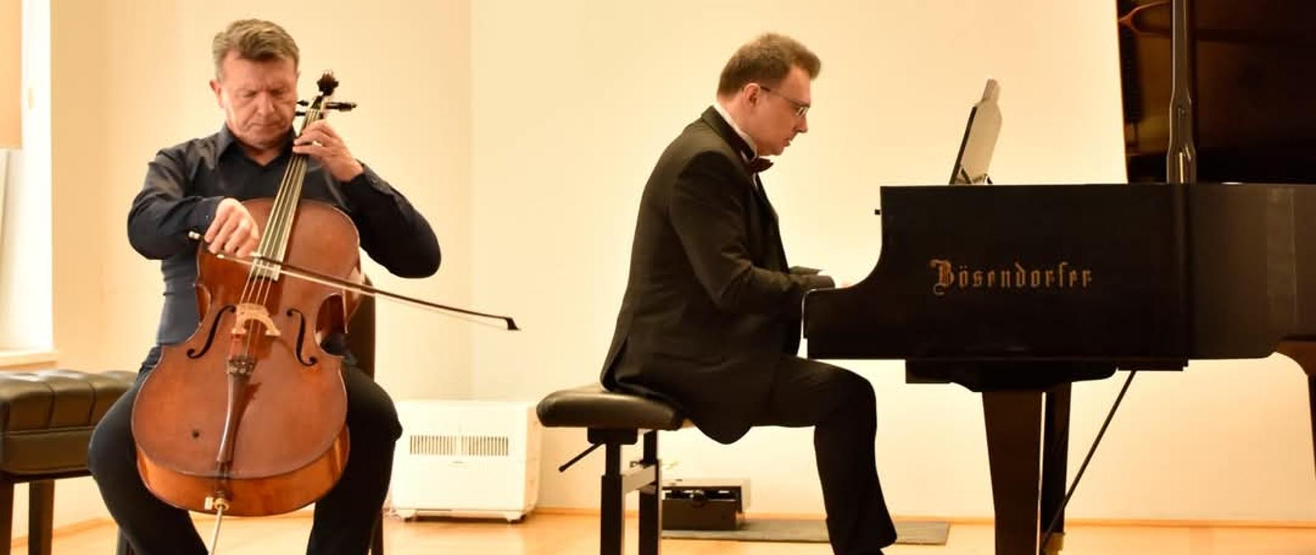 na scenie dwóch mężczyzn jeden gra na fortepianie jeden na wiolonczeli