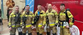 Strażacy stoją przed startem w zawodach.