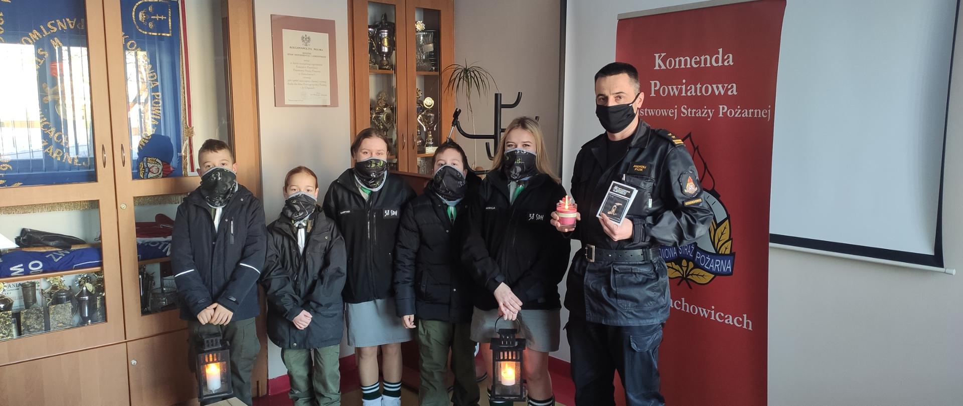 5 harcerzy ZHP Starachowice przekazujący Betlejemskie światełko pokoju strażakowi