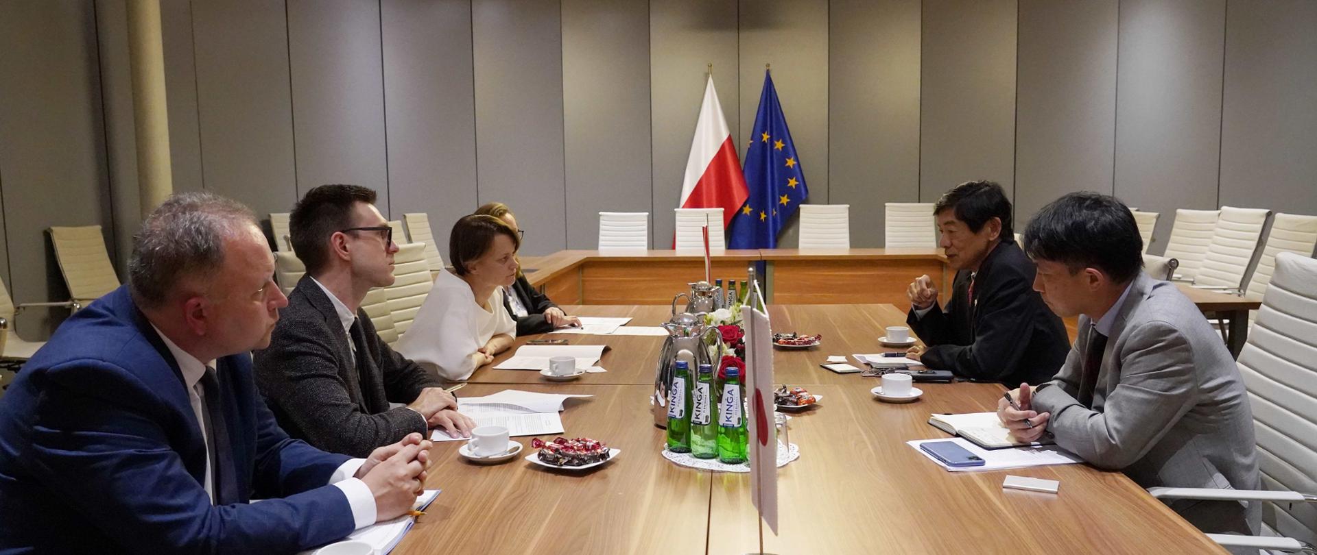 Wiceminister Jadwiga Emilewicz (po lewej stronie) wraz z pracownikami siedzi przy stole i rozmawia z przedstawicielami z Japonii