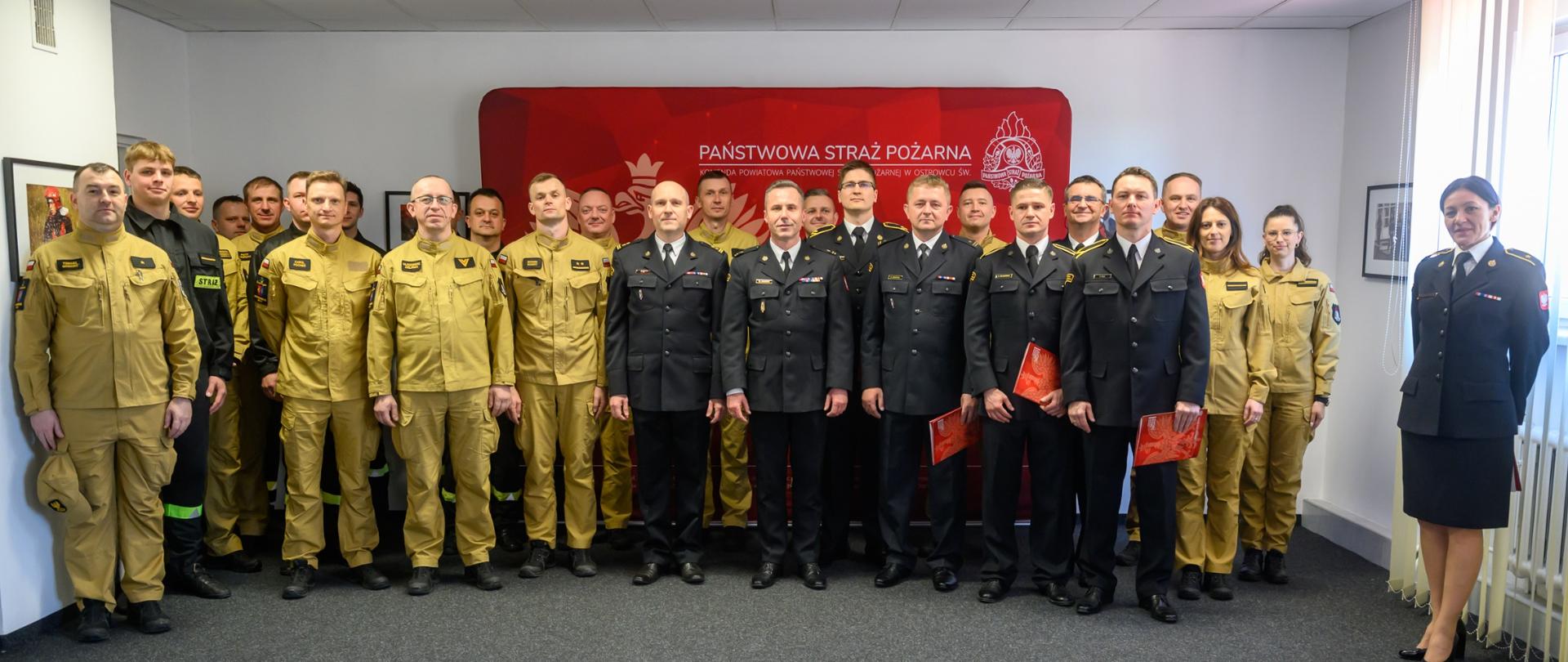 Na zdjeciu widoczni są funkcjonariusze oraz Kierownictwo z komendy powiatowej Państwowej Straży Pożarnej w Ostrowcu Świętokrzyskim podczas wspólnego zdjecia z mianowanymi funcjonariuszami.