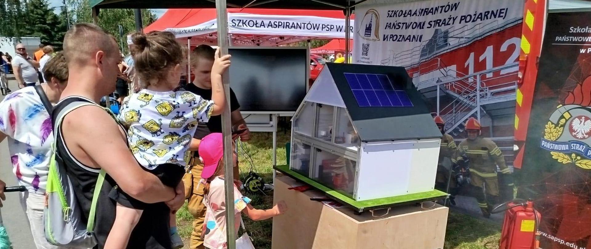 Na zdjęciu ludzie oglądający symulacje pożaru domu