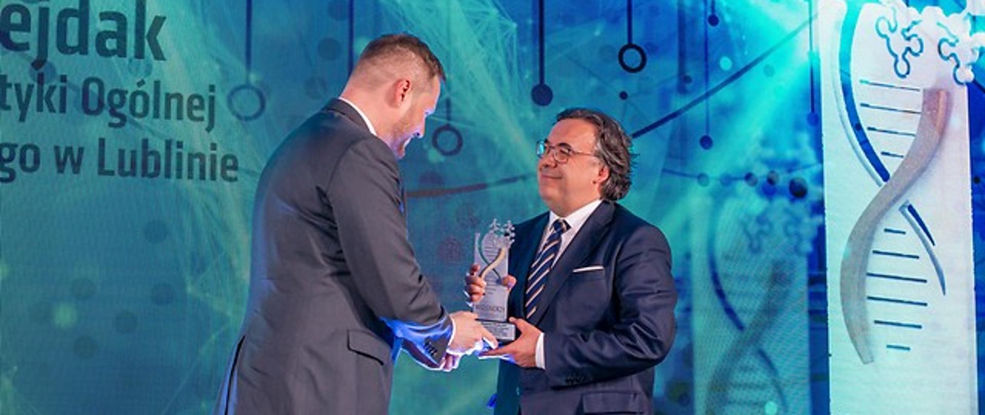 Minister Janusz Cieszyński wręcza profesorowi Robertowi Rejdakowi statuetkę Wizjonera Zdrowia tygodnika "Wprost"