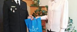 Komendant Powiatowy wręcza podziękowanie dyrektor szkoły w Tuchorzy.