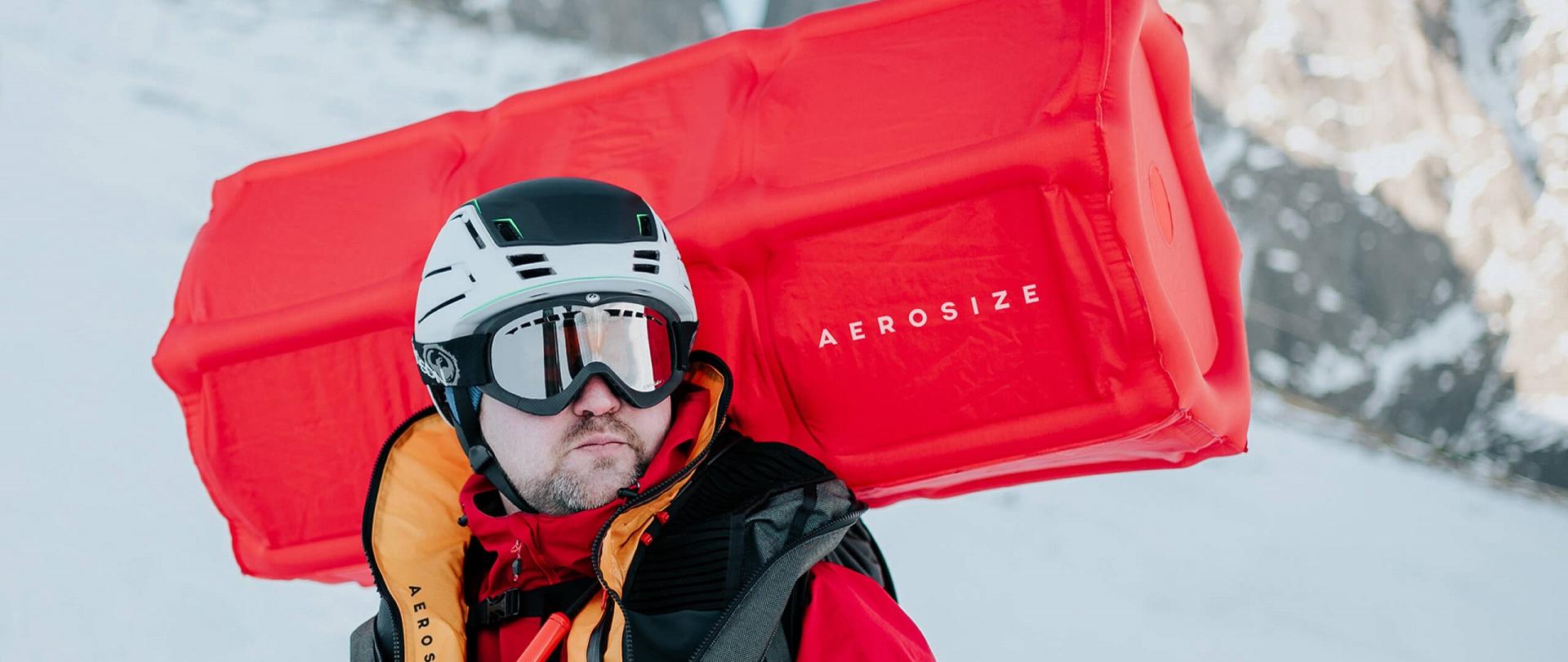 Członek zespołu Maciej Roth w uruchomionej poduszce lawinowej AEROSIZE, zimą, w górach
