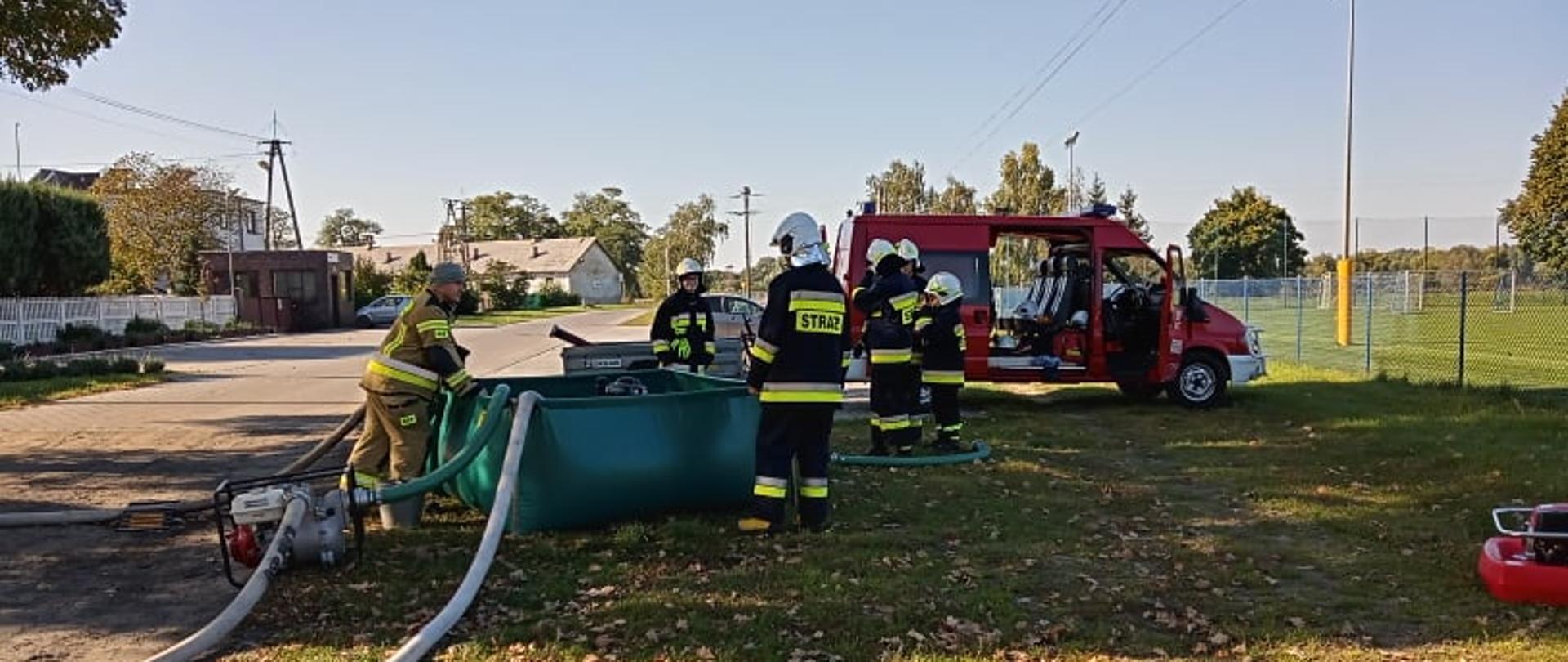 SAMOCHÓD POŻARNICZY, STRAŻACY ĆWICZĄ PRZY ZBIORNIKU WODNYM