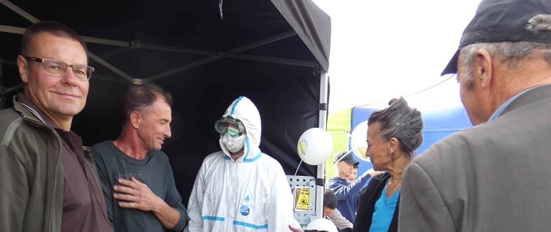 grupa osób przy stoisku informacyjnym