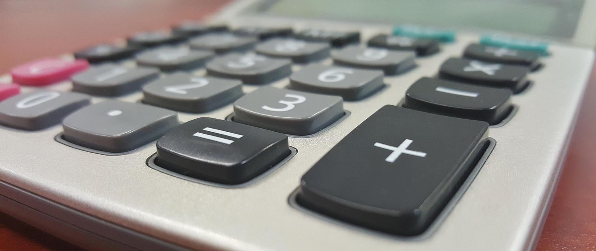 Kalkulator leży na biurku.