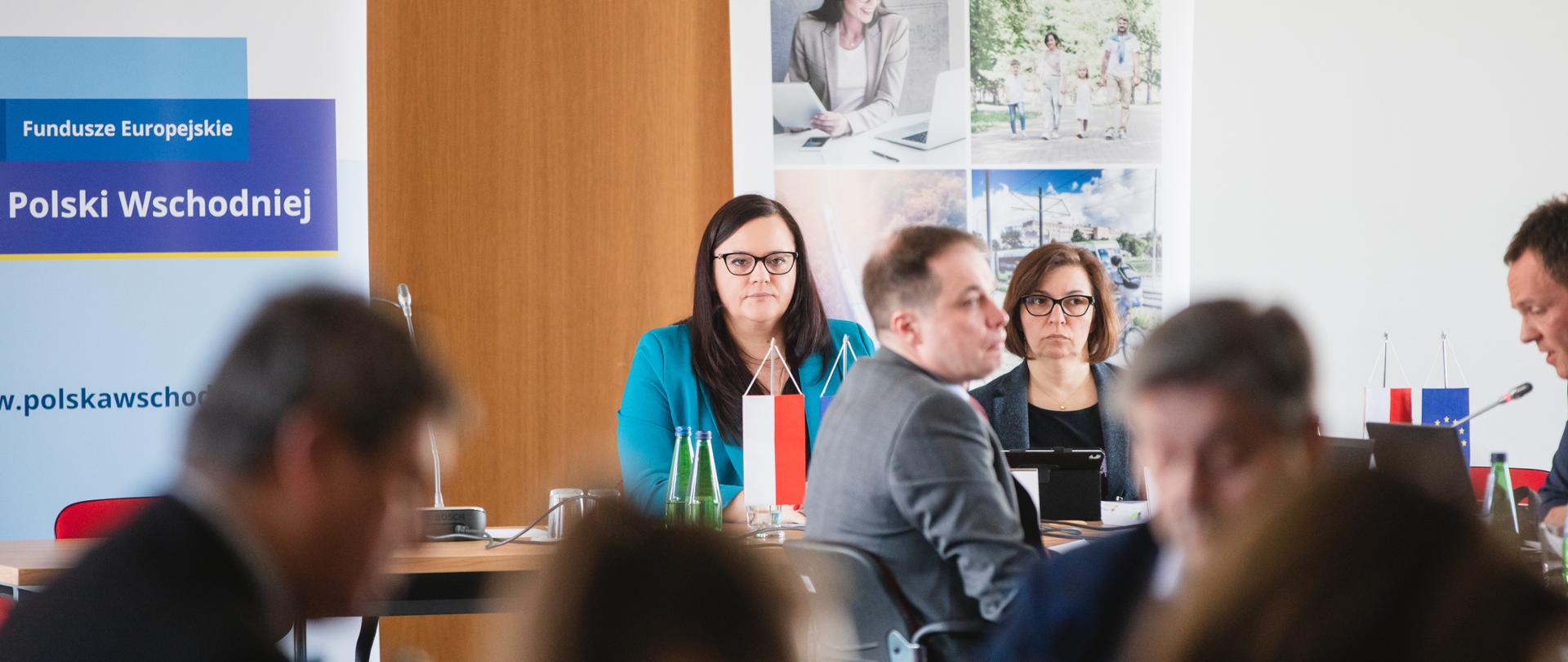 Dwie osoby siedzą przy stole. Pierwsza z lewej siedzi wiceminister Małgorzata Jarosińska-Jedynak.