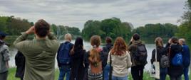 Grupa osób obserwująca ptaki przez lornetki