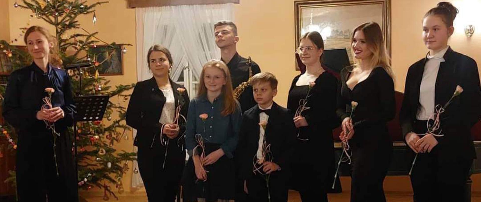 zdjęcie przedstawia od lewej strony nauczycielkę naszej szkoły Anne Guję oraz uczniów szkoły muzycznej w Mielcu w Kolbuszowskim Muzeum Kultury Ludowej