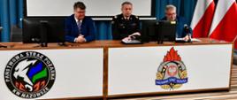 Widać siedzących przy stole konferencyjnym: ministra SWiA Macieja Wąsika, zastępcę komendanta głównego PSP nadbryg. Arkadiusza Przybyłę, przedstawicielem władz samorządowych