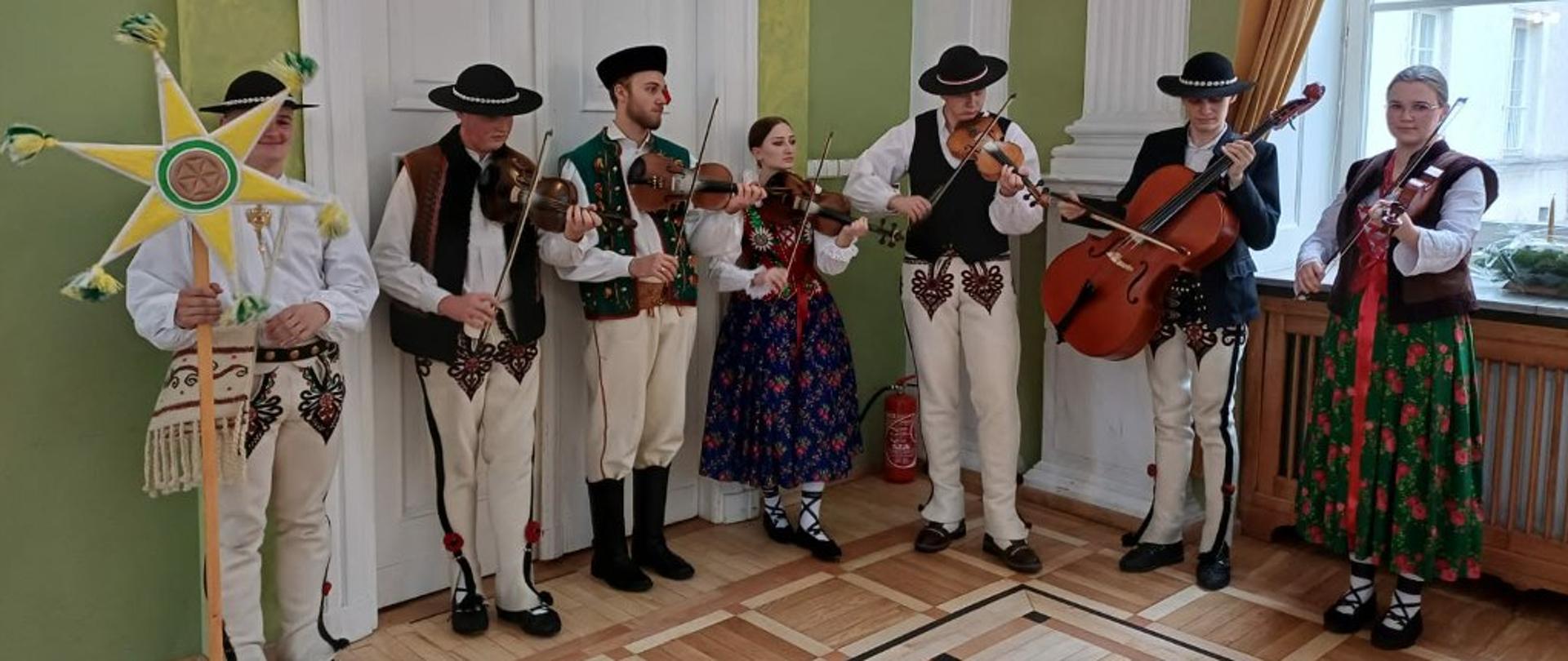 Zdjęcie członków szkolnego zespołu góralskiego grających na instrumentach muzycznych
