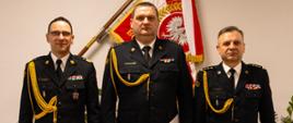 Komendant główny Państwowej Straży Pożarnej nadbryg. Wojciech Kruczek powołał z dniem 14 lutego 2026 r. st. bryg. Dariusza Łukaszewicza na stanowisko zastępcy podlaskiego komendanta wojewódzkiego Państwowej Straży Pożarnej - komendant główny PSP, komendant wojewódzki PSP i nowy zastępca PKW PSP, w tle sztandar KG PSP