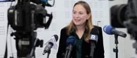 Minister funduszy i polityki regionalnej Katarzyna Pełczyńska-Nałęcz stoi przy mikrofonach