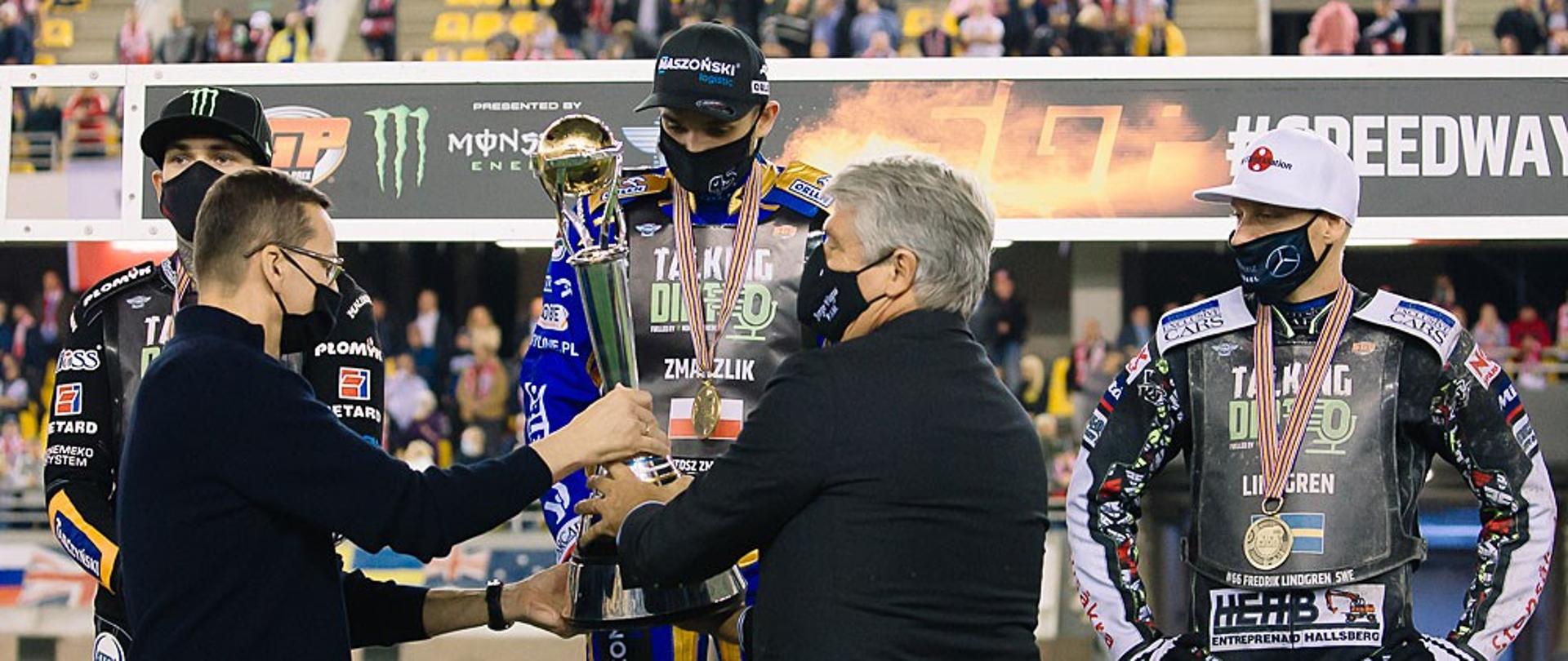 Premier wręcza puchar Bartoszowi Zmarzlikowi.