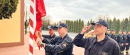 Strażacy wciągają flagę Polski na maszt
