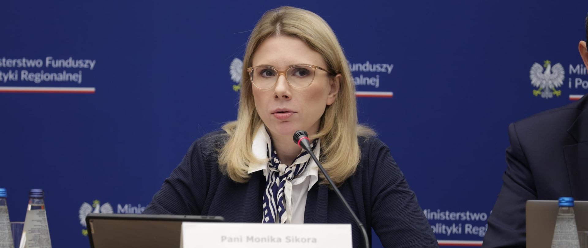 Na zdjęciu wiceminister Monika Sikora siedzi za stołem konferencyjnym