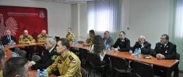 W sali konferencyjnej KP PSP w Ostrowcu Św. siedzą przy stolikach zaproszeni goście oraz strażacy. Na głównym planie widzimy Zastępcę KW PSP w Kielcach oraz Prezydent Ostrowca Św. Artur Łakomiec