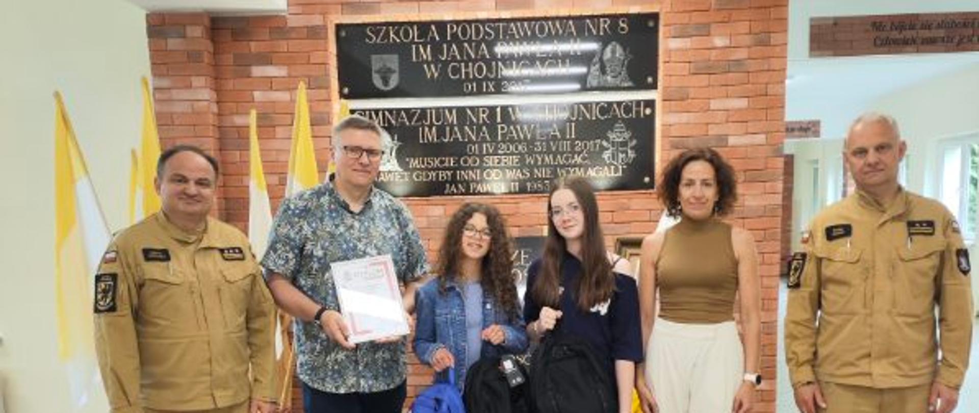 Uroczyste wręczenie nagród laureatom konkursu „Znam Poradnik Bezpieczeństwa” w Szkole Podstawowej nr 8 w Chojnicach. Na zdjęciu uczniowie, nauczyciele oraz przedstawiciele Państwowej Straży Pożarnej: st. bryg. Henryk Koźlewicz i bryg. Rafał Buszek.