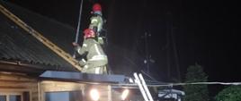 Na zdjęciu widoczni są ratownicy podczas prowadzenia działań polegających na zabezpieczeniu uszkodzonego dachu.