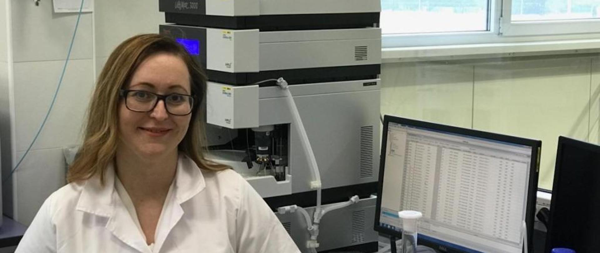 Doktorantka na tle aparatury badawczej