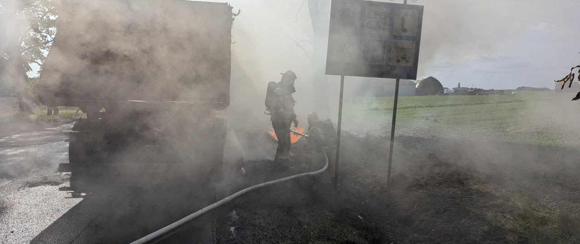 Na zdjęciu widać rotę strażaków gaszących ciągnik siodłowy z naczepą.