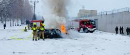 Strażacy gaszący samochód