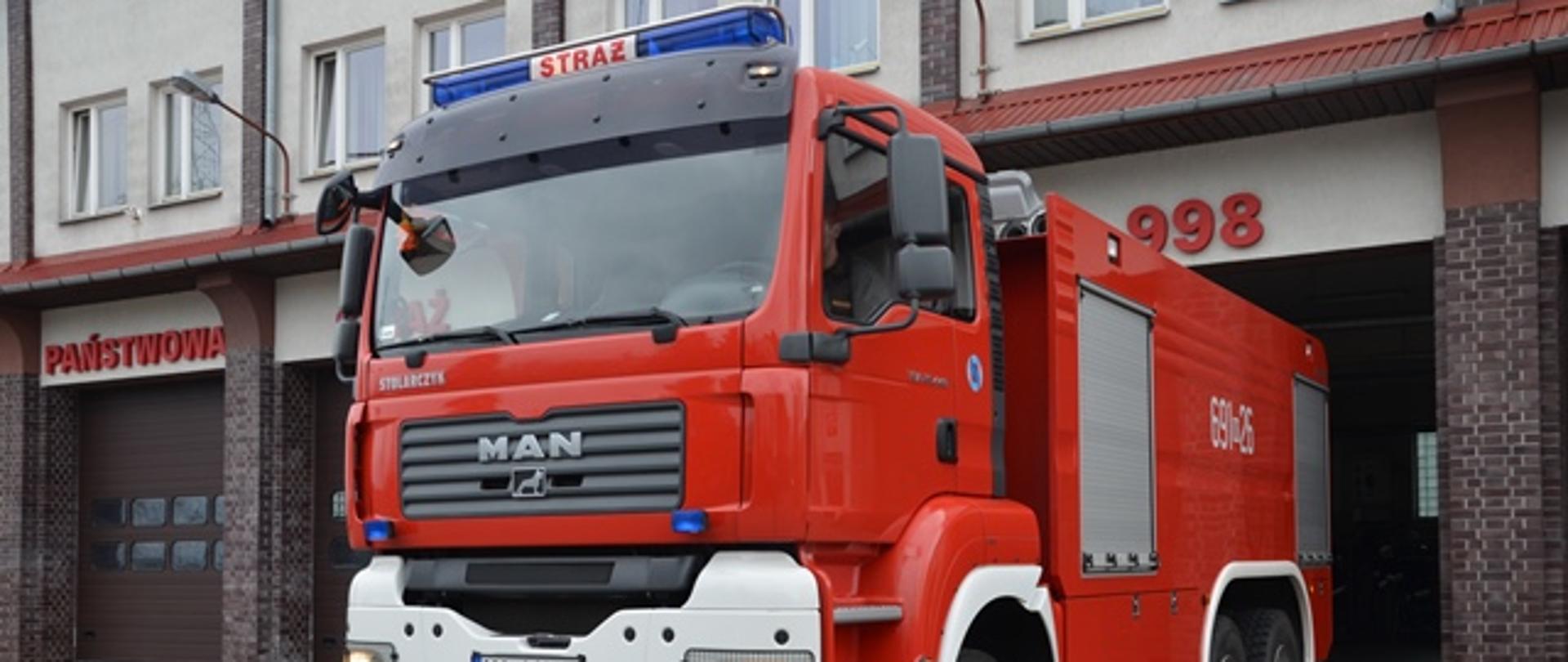 Pojazd strażacki na tle Komendy Powiatowej PSP
