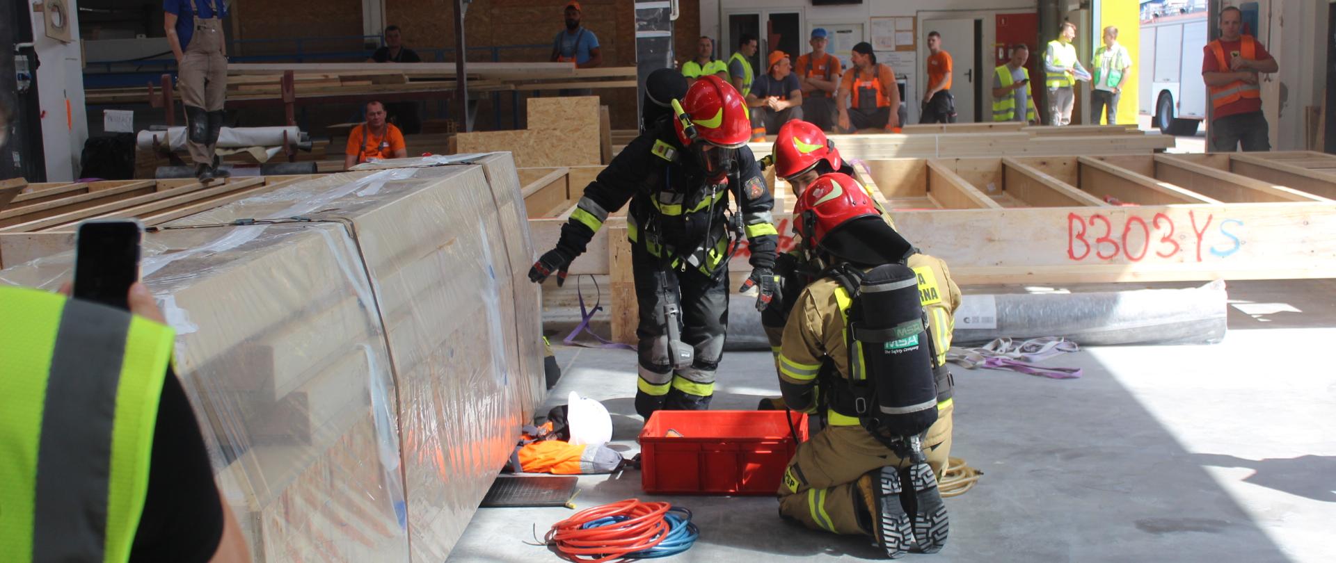 Ćwiczenia strażackie - strażacy podczas symulowanej akcji wydobywania spod ciężkiego elementu przygniecionej osoby.