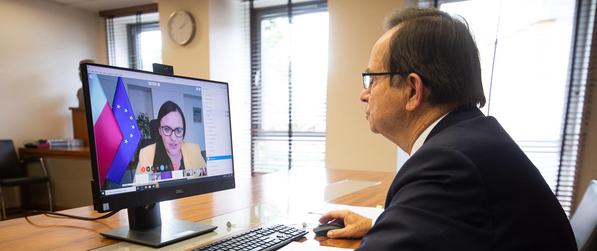 W pomieszczeniu przy biurku siedzi przed monitorem marszałek W. Ortyl. Na ekranie minister M. Jarosińska-Jedynak