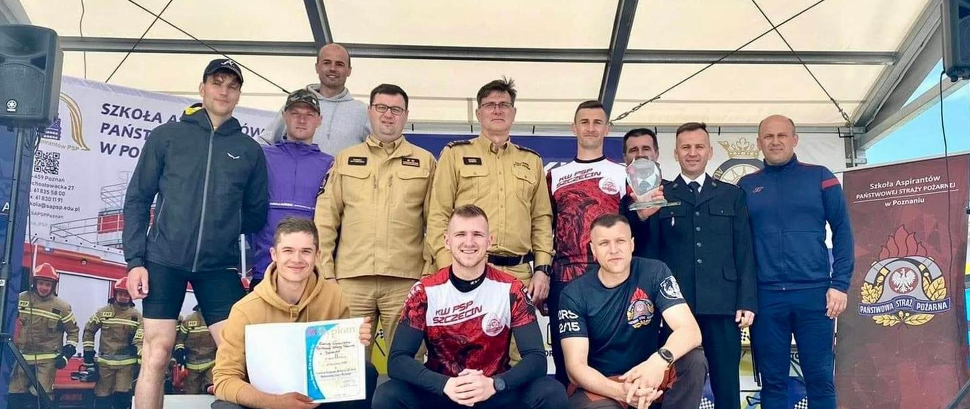 Reprezentacja województwa zachodniopomorskiego na zdjęciu grupowym razem z nagrodą za zajęcie 2 miejsca, w tle tor rozbiegowy, las