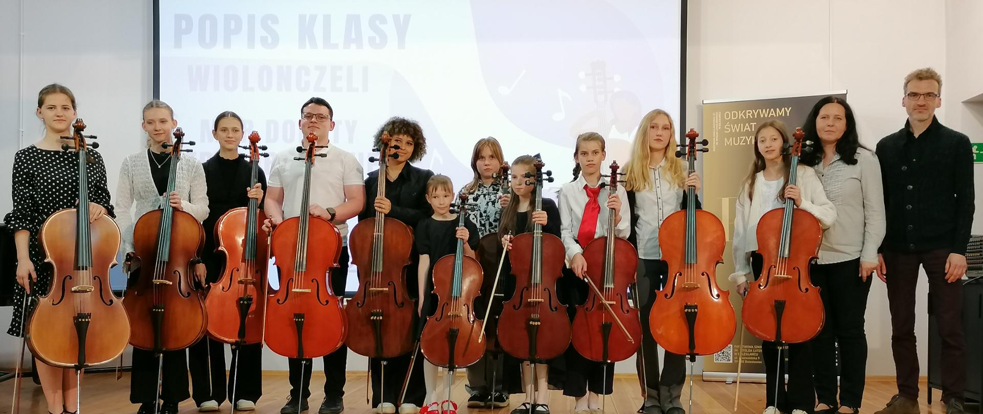 Zdjęcie przedstawiające wykonawców popisu klasy wiolonczeli mgr Doroty Straburzyńskiej, który odbył się 29 maja 2025 r. w auli szkoły.
