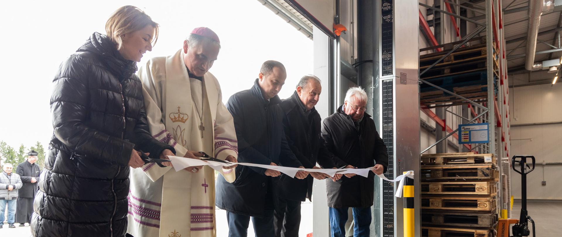 Pięć osób podczas przecinania wstęgi