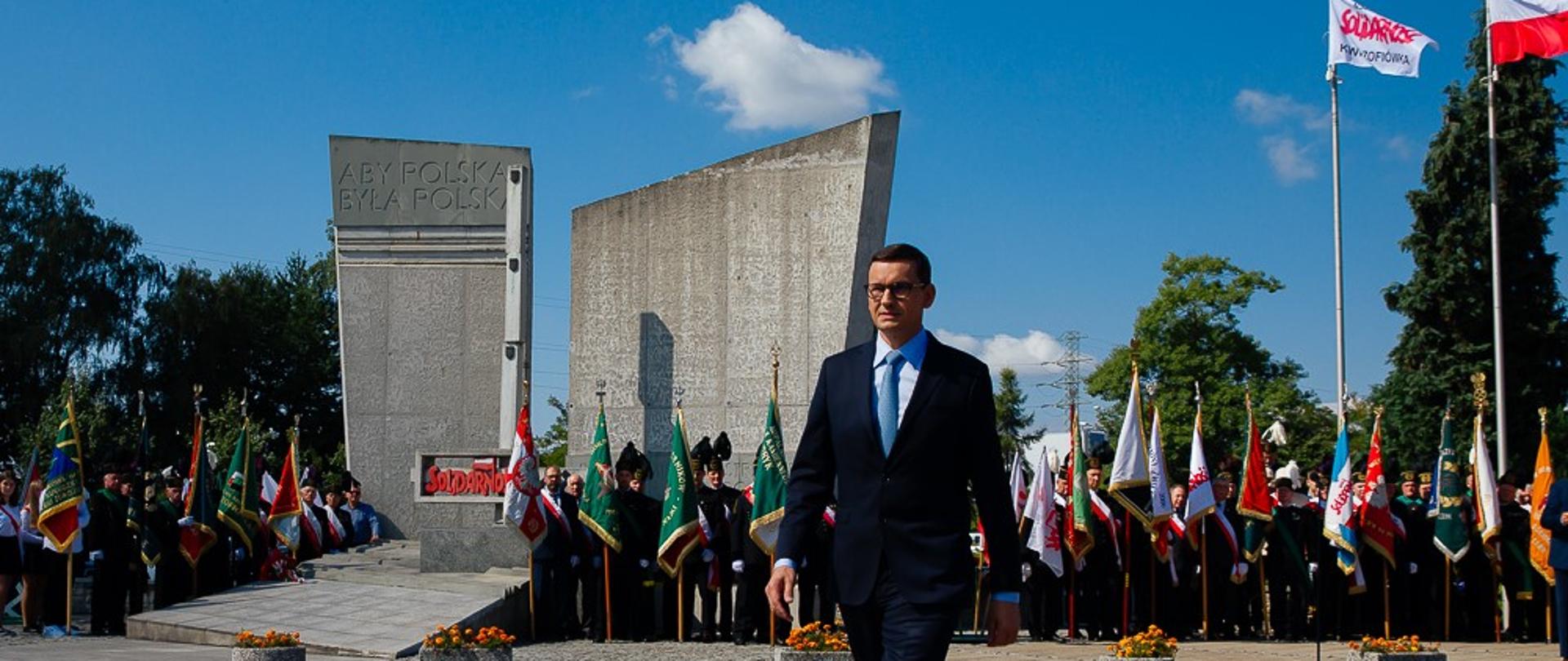 Premier maszeruje przez plac podczas uroczystości.