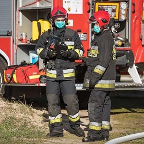 strażacy na tle wozu strażackiego