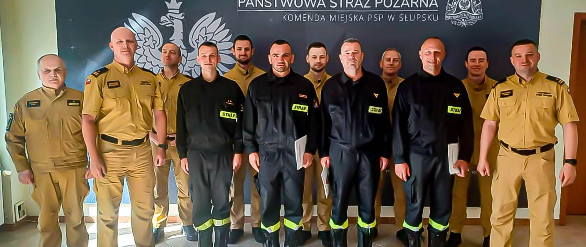 Zdjęcie przedstawia uczestników uroczystość podczas, której mł. bryg. Krzysztof Trocki, komendant miejski PSP w Słupsku wręczył listy pochwalne oraz nagrody finansowe czterem funkcjonariuszom. 